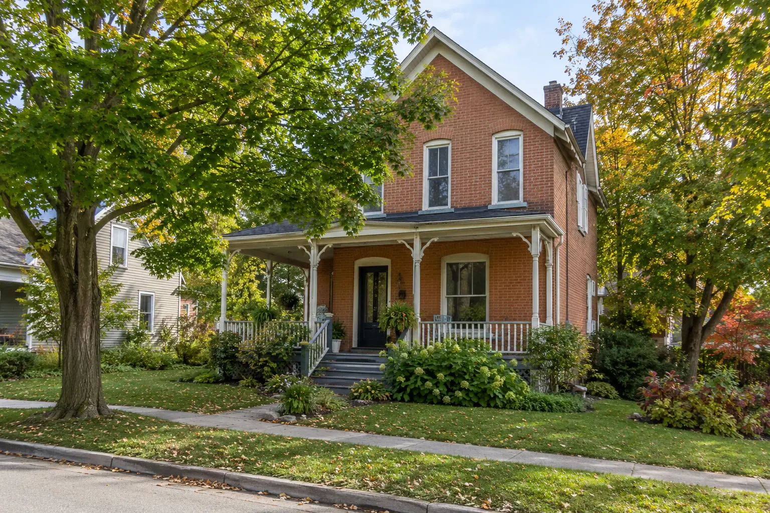 Representative established village home with mature trees and a traditional porch